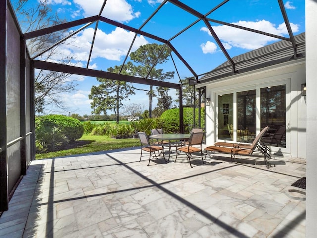 view of patio with outdoor dining space and a lanai