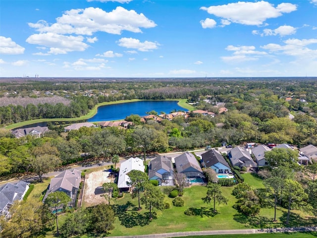 drone / aerial view featuring a forest view, a water view, and a residential view