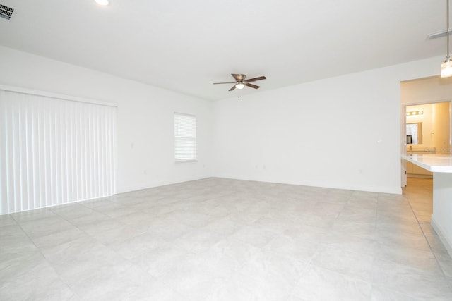 empty room featuring visible vents, baseboards, and ceiling fan