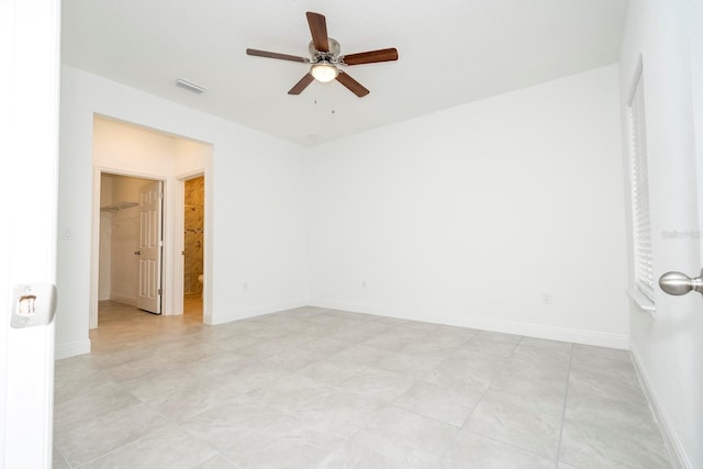 empty room with visible vents, a ceiling fan, and baseboards