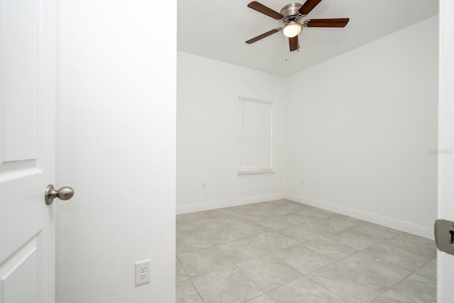 empty room featuring a ceiling fan and baseboards