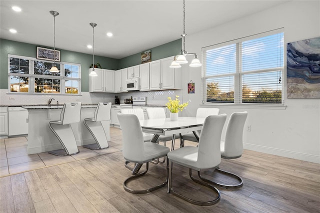 dining room featuring recessed lighting, baseboards, and light wood-style floors