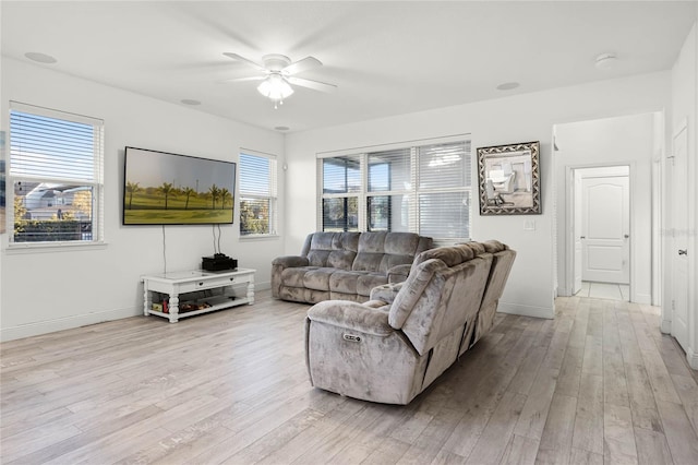 living room featuring light wood-type flooring, baseboards, and ceiling fan