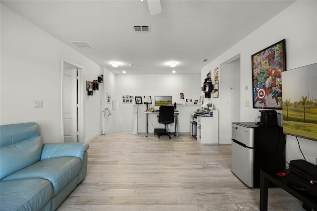 home office featuring light wood-style flooring and visible vents