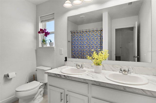 full bathroom with double vanity, toilet, visible vents, and a sink