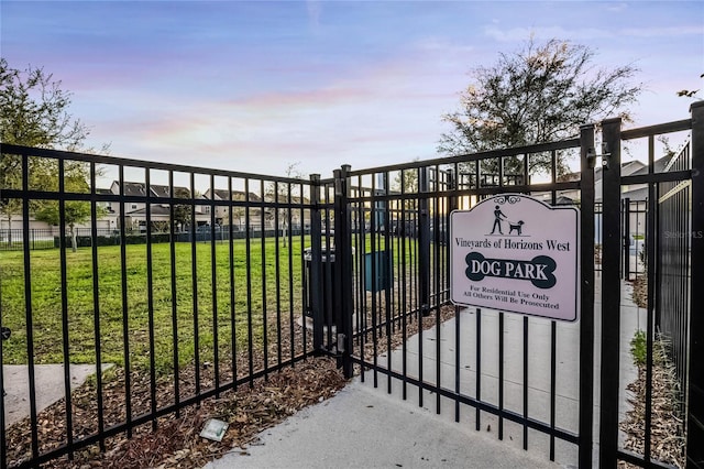 gate at dusk with a yard and fence