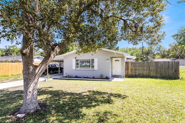 view of front of home featuring a carport, a front yard, and fence