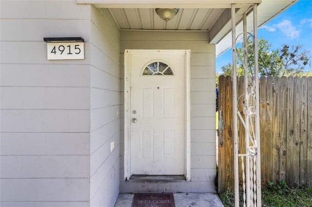 view of exterior entry featuring fence