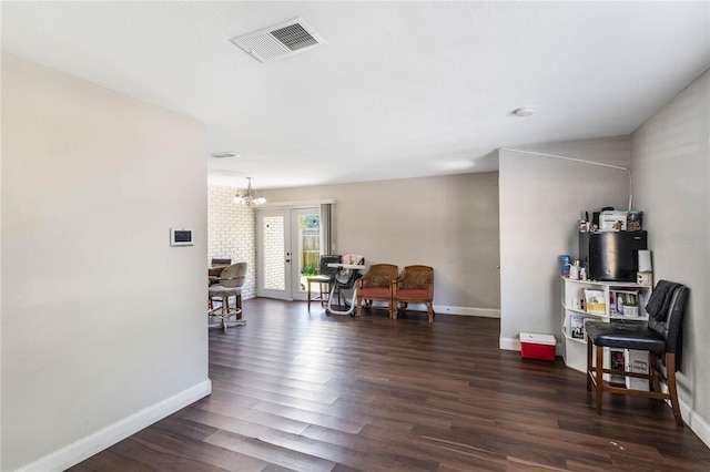 sitting room featuring visible vents, baseboards, a notable chandelier, and dark wood-style flooring