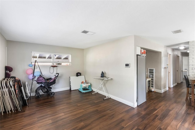 interior space with wood finished floors, visible vents, and baseboards