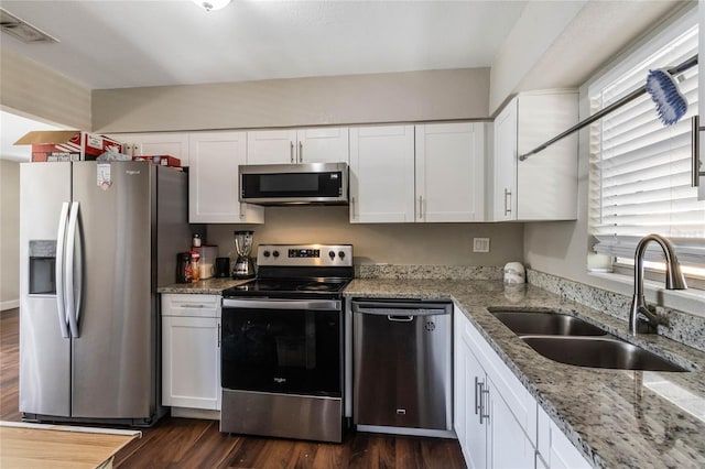 kitchen featuring a sink, stainless steel appliances, visible vents, and white cabinets