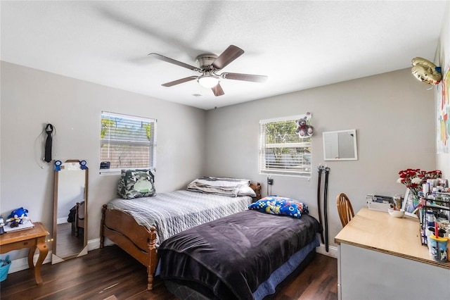 bedroom with dark wood-style floors, baseboards, and ceiling fan