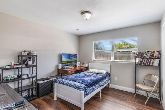 bedroom with baseboards and wood finished floors