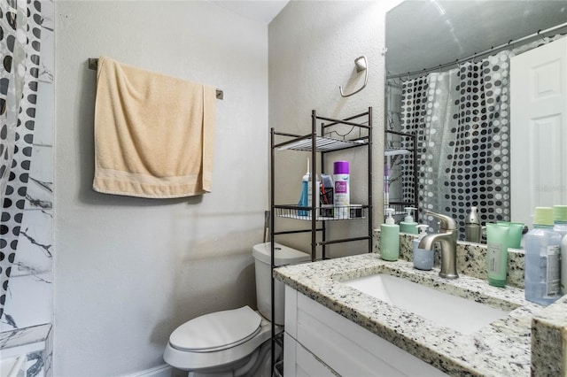 bathroom with curtained shower, toilet, vanity, and a textured wall