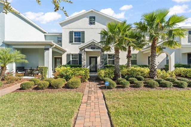 view of front of property featuring stucco siding and a front lawn