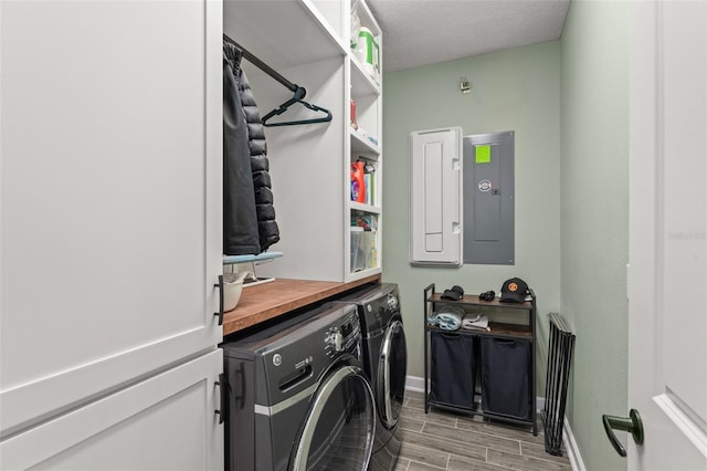 laundry area with baseboards, wood finish floors, laundry area, electric panel, and washer and dryer