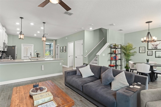 living room featuring visible vents, recessed lighting, stairs, and wood finished floors