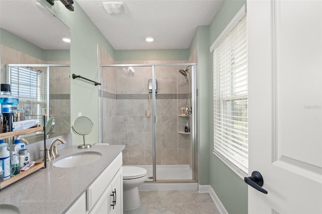 full bathroom featuring a shower stall, baseboards, toilet, tile patterned floors, and vanity