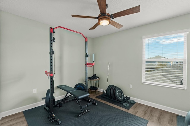 workout area with ceiling fan, baseboards, and wood finished floors