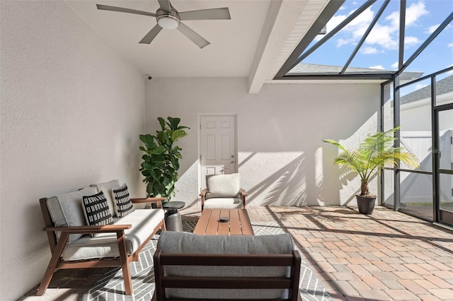 view of patio / terrace featuring glass enclosure, an outdoor living space, and a ceiling fan