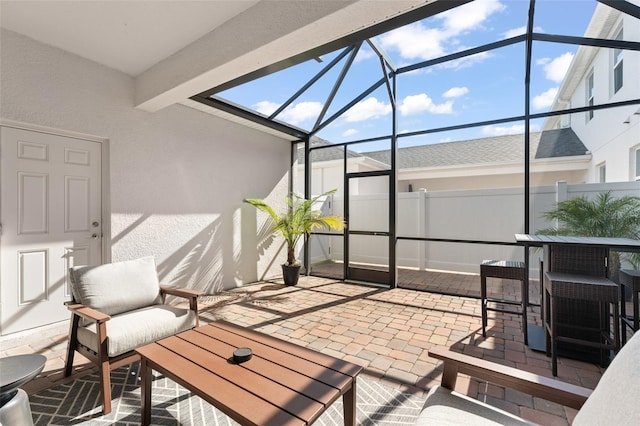 view of patio with glass enclosure and fence