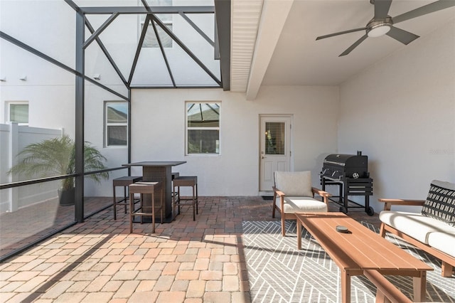 view of patio with glass enclosure, grilling area, and ceiling fan