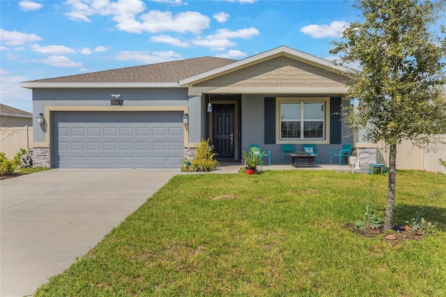 view of front of property featuring a front lawn, fence, stucco siding, driveway, and an attached garage