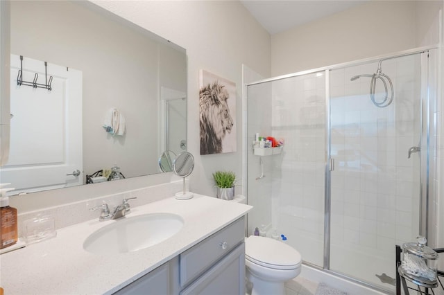 bathroom featuring vanity, a shower stall, and toilet