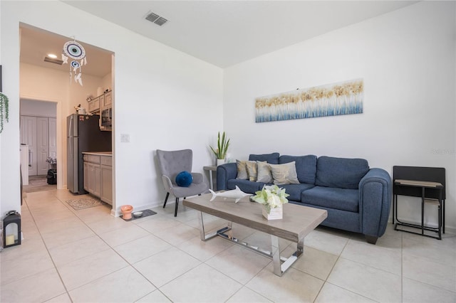 living room featuring visible vents, baseboards, and light tile patterned flooring