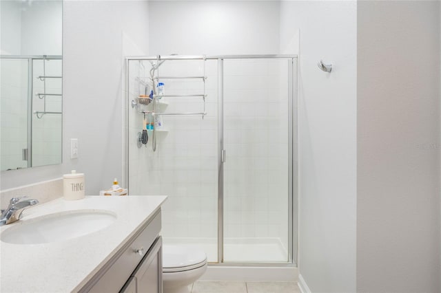 bathroom featuring vanity, tile patterned floors, toilet, and a stall shower