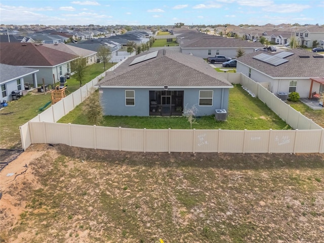 view of front of house with a front yard, a fenced backyard, a residential view, and central AC