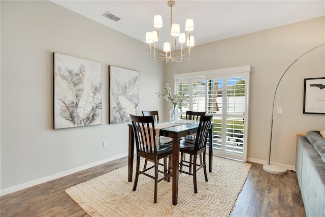dining space with visible vents, an inviting chandelier, baseboards, and wood finished floors