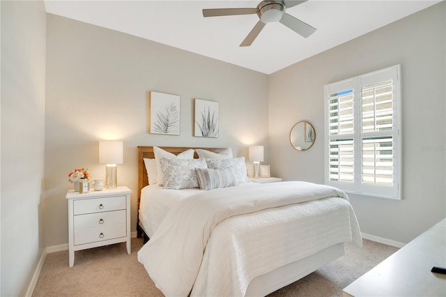 bedroom featuring baseboards, light colored carpet, and ceiling fan