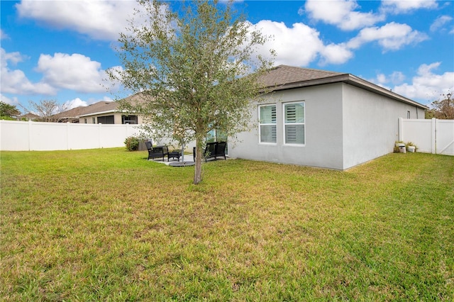 rear view of property featuring a yard, stucco siding, a patio, and a fenced backyard