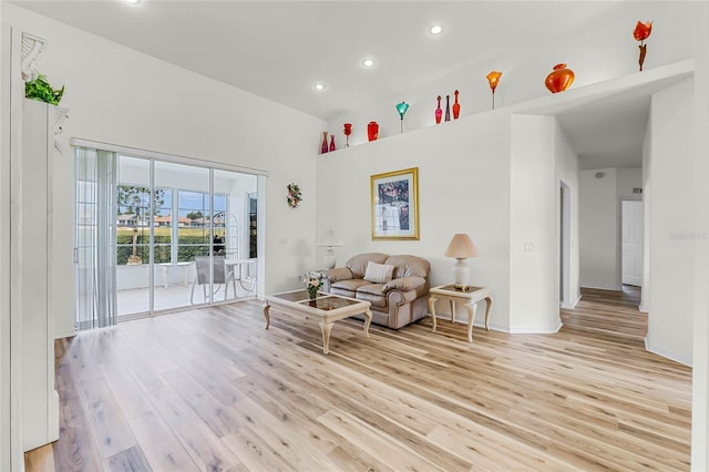 living room with recessed lighting, light wood-style flooring, baseboards, and vaulted ceiling