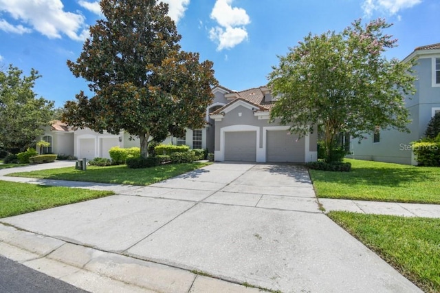 view of front of property with stucco siding, a front lawn, a tile roof, concrete driveway, and a garage