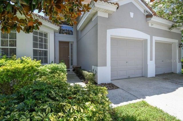 exterior space featuring stucco siding, concrete driveway, and a garage