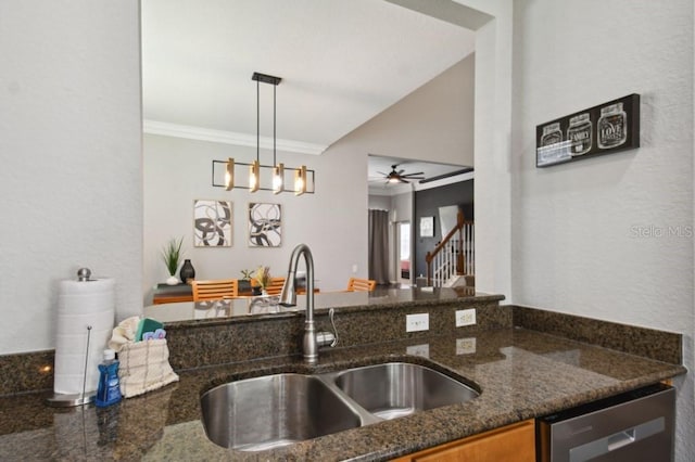 kitchen featuring a sink, ornamental molding, dark stone countertops, hanging light fixtures, and stainless steel dishwasher