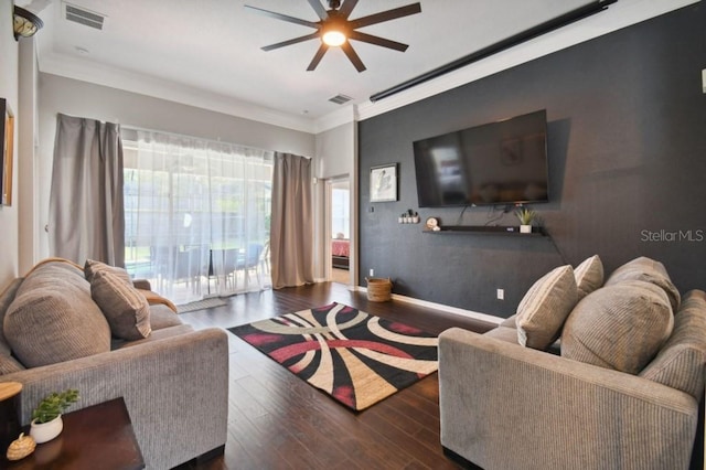 living area featuring visible vents, baseboards, ornamental molding, wood finished floors, and a ceiling fan