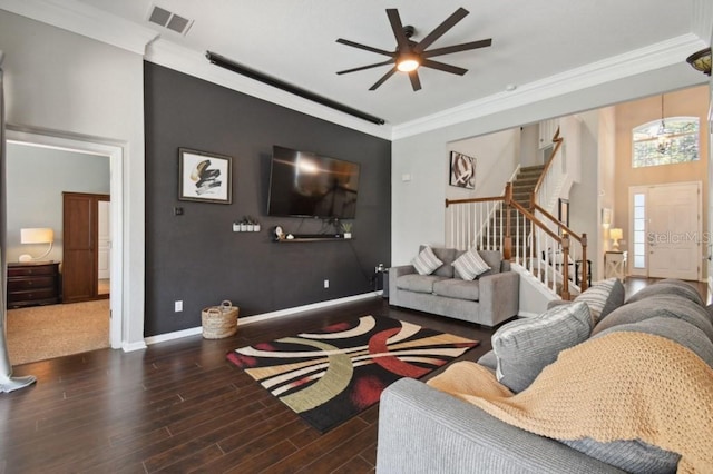 living area featuring stairway, wood finished floors, baseboards, visible vents, and ornamental molding