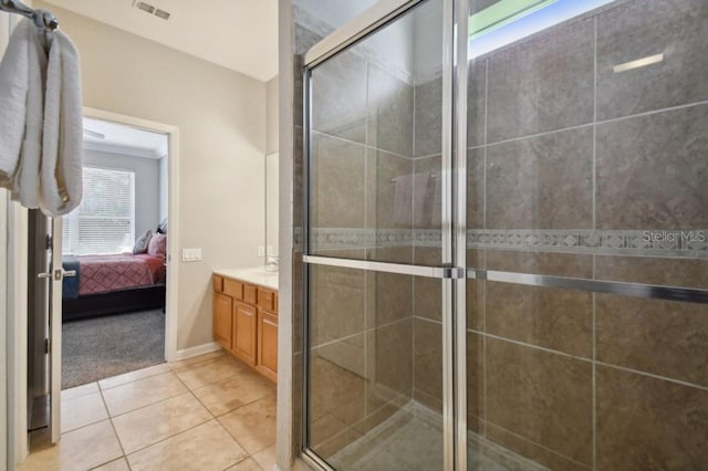 ensuite bathroom with ensuite bathroom, vanity, a shower stall, and tile patterned flooring