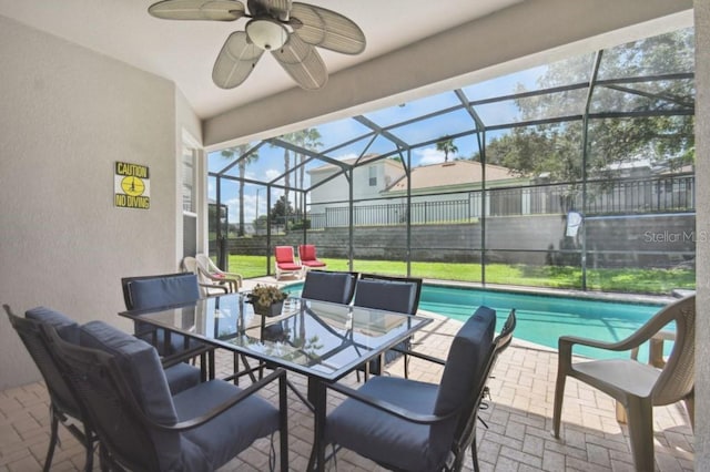 view of patio featuring glass enclosure, an outdoor pool, ceiling fan, and fence