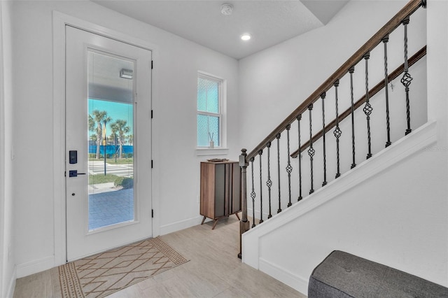 foyer entrance featuring stairs, recessed lighting, and baseboards