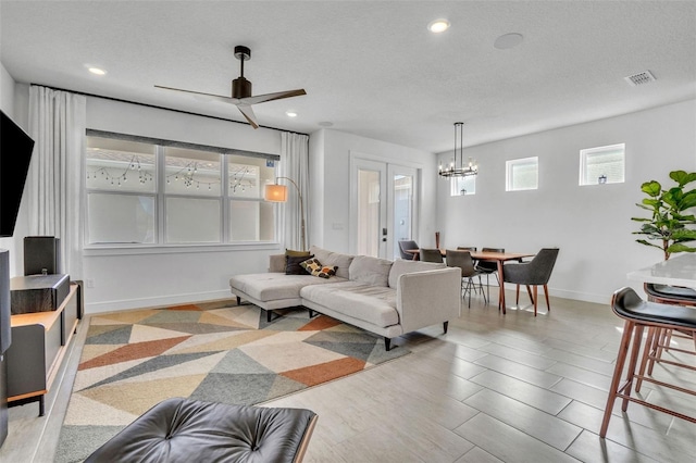 living area featuring recessed lighting, visible vents, baseboards, and a textured ceiling