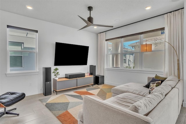 living area featuring recessed lighting, baseboards, and ceiling fan