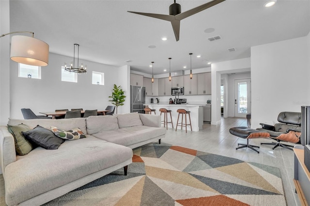 living room with recessed lighting, visible vents, and a chandelier