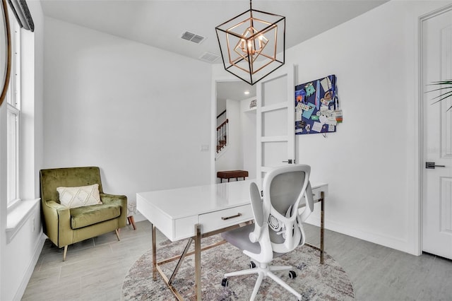 office space with visible vents, baseboards, an inviting chandelier, and light wood-style flooring