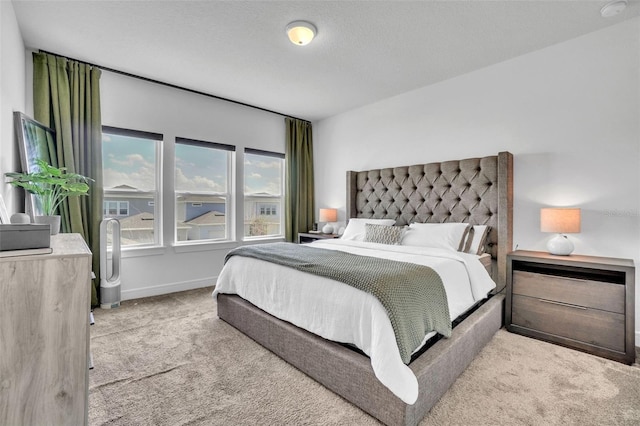 bedroom with carpet, baseboards, and a textured ceiling