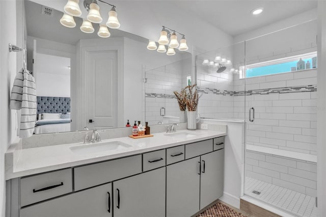 bathroom featuring a sink, ensuite bath, a stall shower, and double vanity