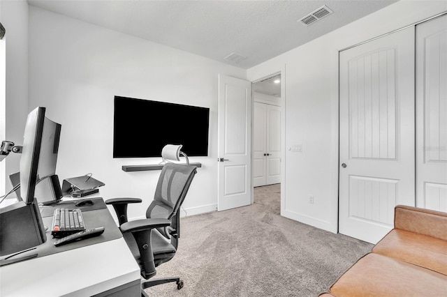 home office with baseboards, visible vents, carpet floors, and a textured ceiling